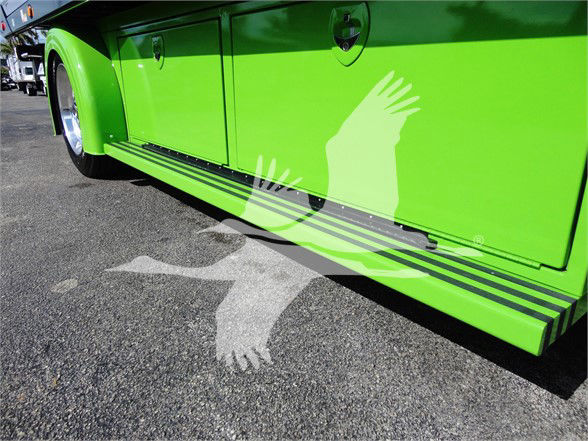 Green Peterbilt 337 side view showing lower side step and storage compartments along the cargo area.