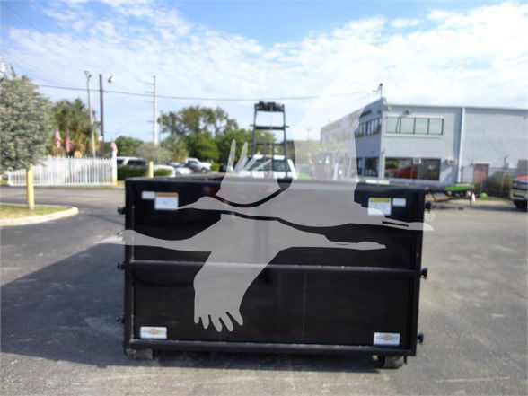 Truck dump hopper/box with silhouette graphic of a bird in flight. Visible labels on the sides of the hopper. Parking lot with dealership buildings in background.