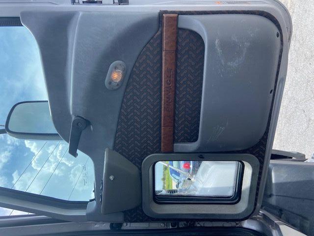 2010 Mack CXU613 truck door panel showing interior with textured fabric, brown trim, and light on door.