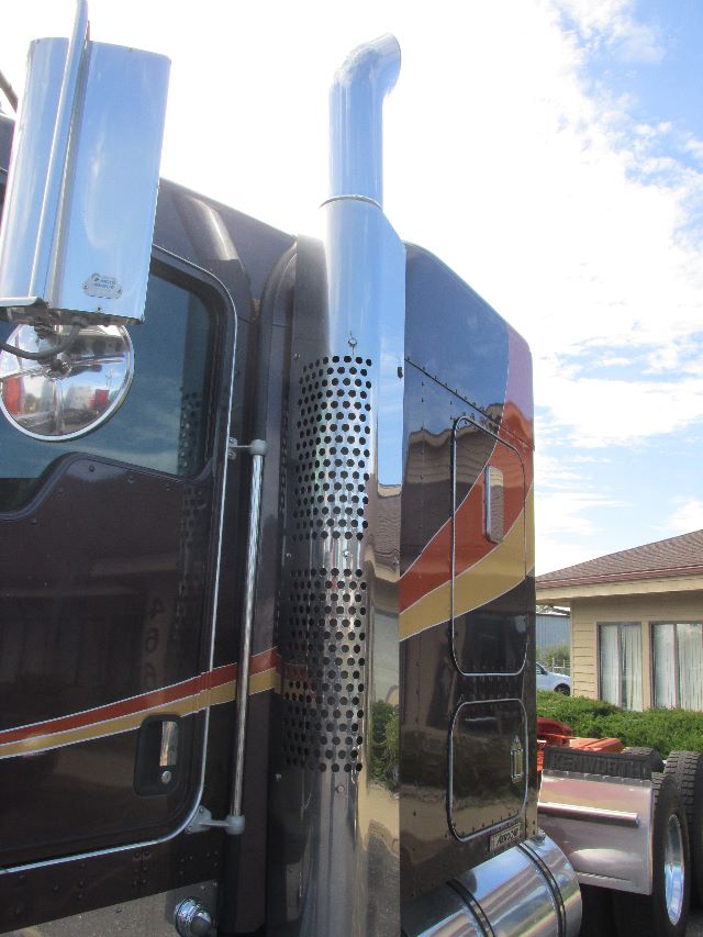 Kenworth W900 truck cab with chrome exhaust stack and perforated heat shield, side profile view showing glossy black paint with red, yellow stripe detailing.