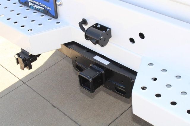 Rear view of a Ford F-250 truck hitch area showing a square hitch receiver, bumper, and utility wiring mounts.