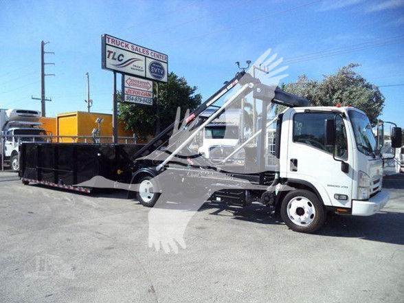 Isuzu NRR tow truck with a long flatbed and crane arm visible.