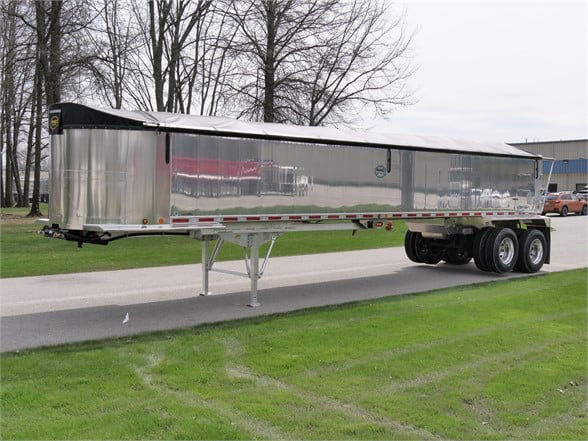 Trailer: 2023 Alum Lightweight Frameless dump trailer with polished aluminum sides, dual rear axles, and landing gear visible.