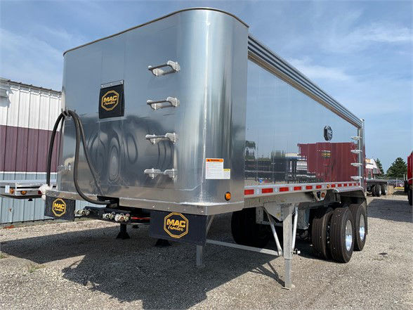 24ft aluminum dump trailer with top hinge door, twin rear doors, and dual axles. Shiny silver body with MAC trailer logo, rear view shows landing gear and rear bumper.