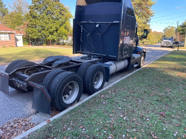 Kenworth T600 conventional sleeper tractor chassis showing rear triple-axle configuration and exhaust stack.