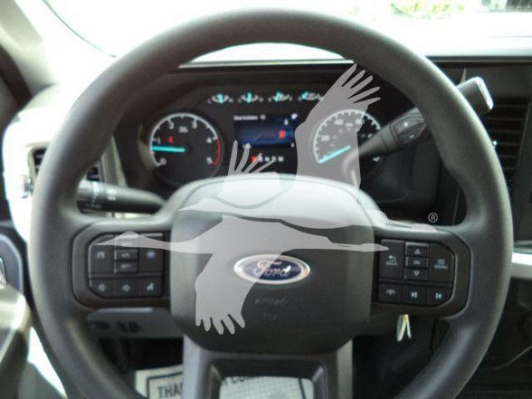 Ford steering wheel with Ford logo and dashboard visible, inside a 2024 F-450 Tow truck.