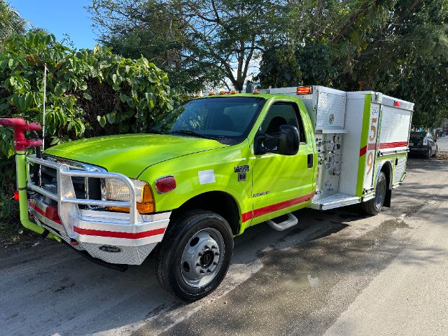 2001 Ford F-550 fire rescue truck in bright lime-yellow color, front grille guard, side compartments, 'Fire' markings and reflective stripes along body.