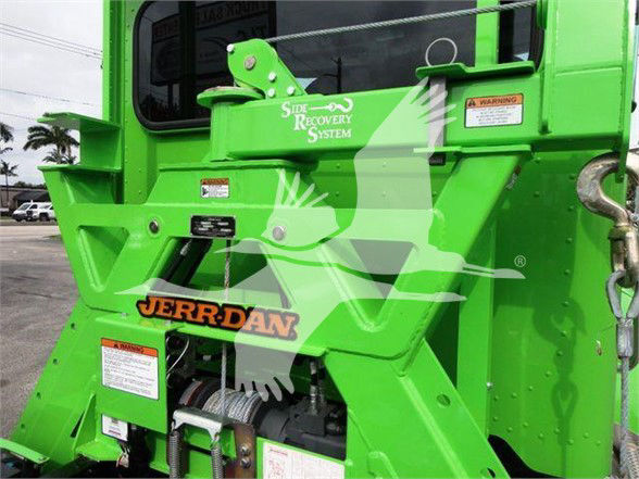 Green Peterbilt 337 tow truck rear section with lifting arm, warning labels, and JERRDAN logo. Visible text includes Side Recovery System and stock/barcode labels.