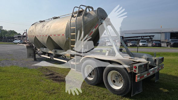 Fruehauf cement tanker trailer mounted on dual-axle chassis with rounded cylindrical tank and access ladder, used condition.