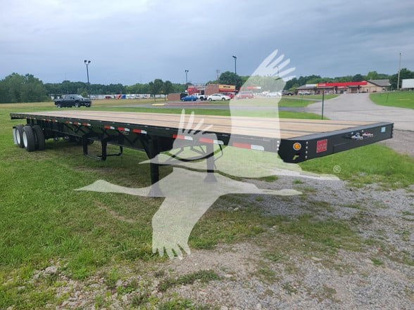 Flatbed trailer showing long steel deck with dual rear axles and landing gear, 2023 Fruehauf steel flatbed trailer in used condition.