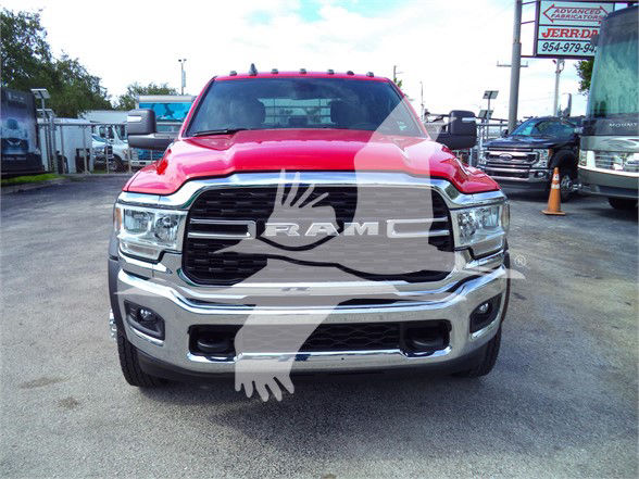 Front view of a red 2023 Ram 5500 SLT pickup truck with RAM grille and chrome bumper in a dealership lot.