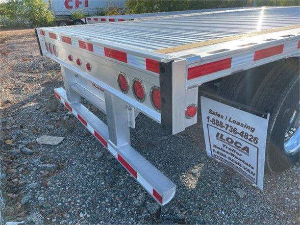 Aluminum Fontaine REVOLUTION 52 53FT flatbed trailer rear corner showing reflective red/white tape and taillight bar.