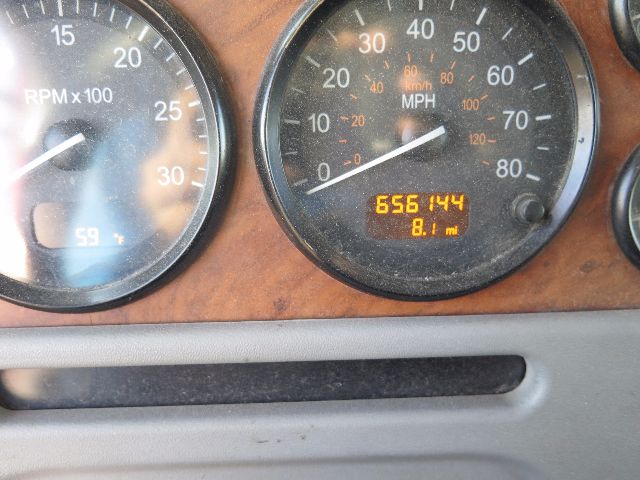 Peterbilt truck dashboard showing speedometer up to 80 mph and an odometer reading 656144 with 8.1 mi显示; tachometer; wood grain dash.