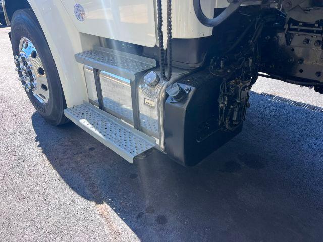 Freightliner M2 106 truck front passenger side showing aluminum steps and fuel tank area.