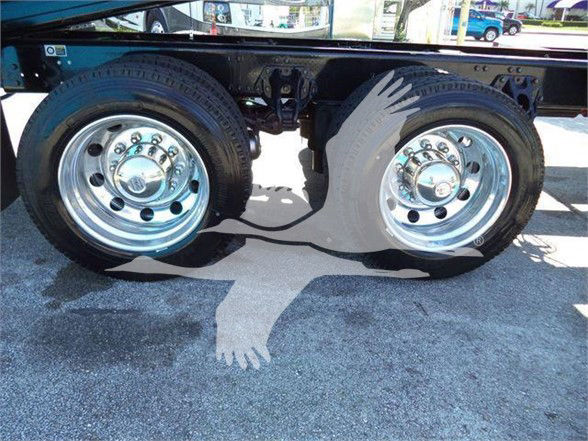 Kenworth T880 dual rear axles with chrome wheel hubs and dual tires in a truck chassis, no visible labels readable.
