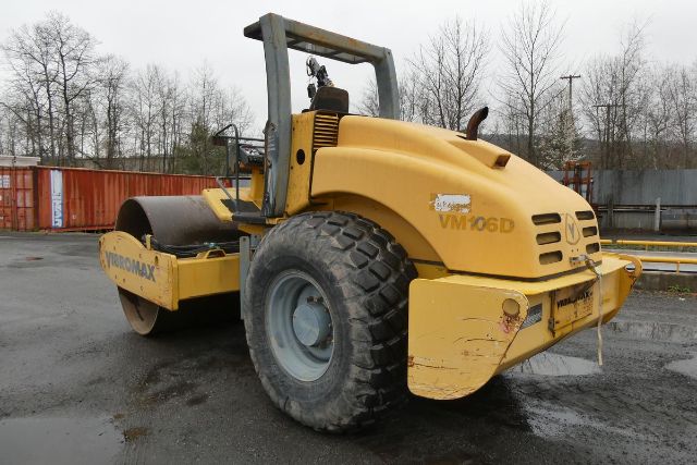 Vibromax VM106D single drum roller in yellow with large rear tire, operator seat, and VM106D markings visible.