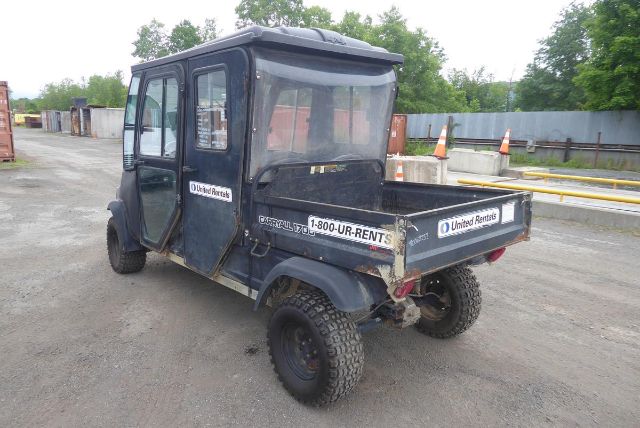Club Car Carryall 1700 utility vehicle in a dusty lot, rear cargo bed visible with U-Haul/United Rentals stickers.