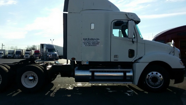 Truck side view showing Freightliner Columbia cab with chrome fuel tanks and wheel, long-nose sleeper cab, rear tractor area.