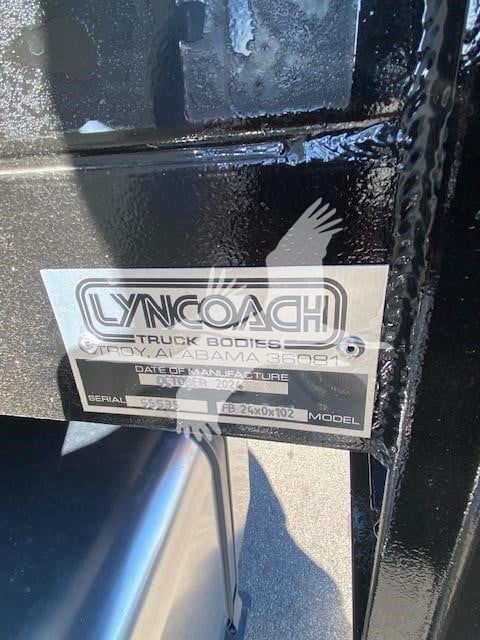 Lyncoash Truck Bodies plate on a black surface showing model and serial information. Reading appears: LYNCOACH TRUCK BODIES, ... SERIAL 55853, FB 26x0102, MODEL ...