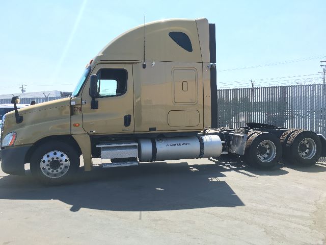 Vehicle side view of a beige 2010 Freightliner Cascadia 125 tractor, sleeper cab, with dual rear axles and visible fuel tank and exhaust, indicating truck profile.
