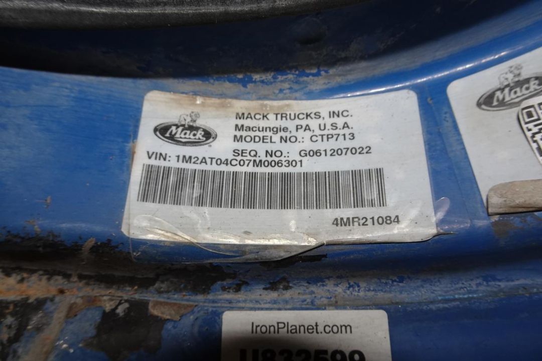 Mack Trucks label on blue machinery showing MODEL NO.: CTP713, VIN: 1M2AT04C07M006301, SEQ. NO.: G061207022, barcode, Mack logo.