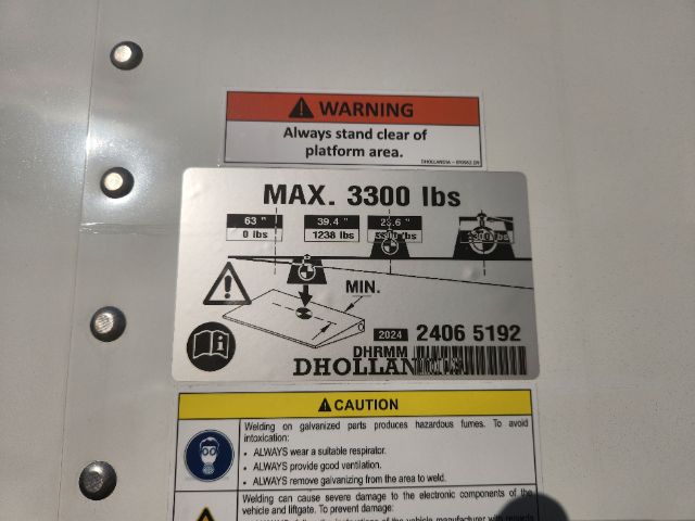Truck chassis area showing warning labels: MAX. 3300 lbs load sticker, platform area instruction, and caution label with welding hazard icons.