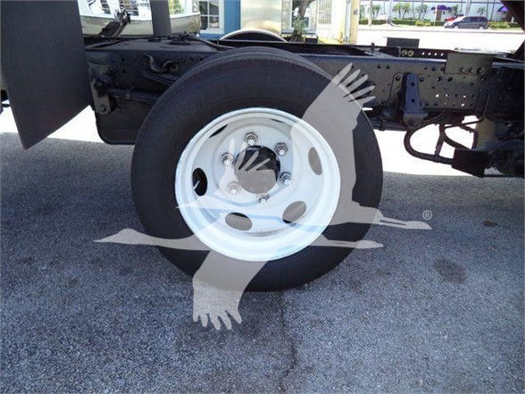 Isuzu NRR truck rear wheel and chassis with white rim showing, side view of suspension and tire.