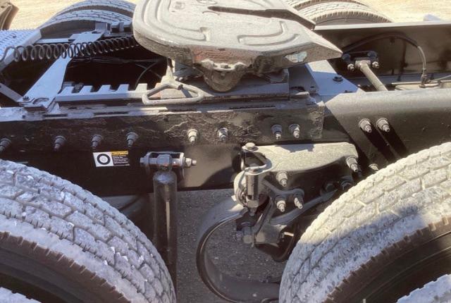 Truck chassis near fifth wheel with visible bolts, hoses, and suspension components. There are no readable labels or text visible in this crop.