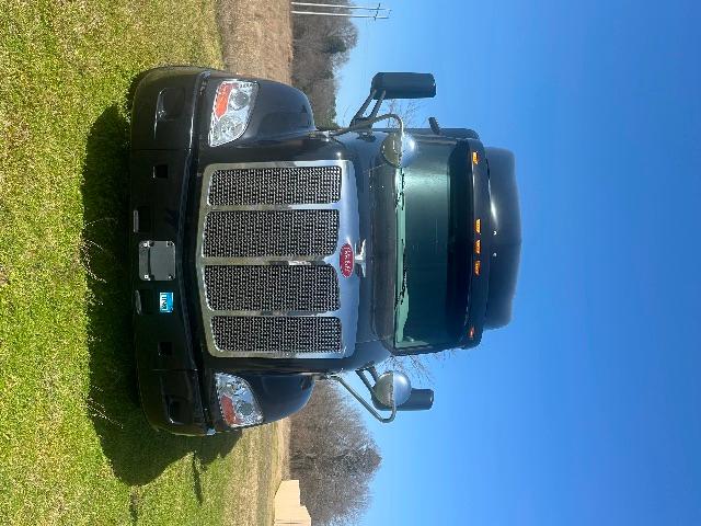 Peterbilt 579 conventional sleeper truck front view showing large grille and emblem, side mirrors, and headlights.