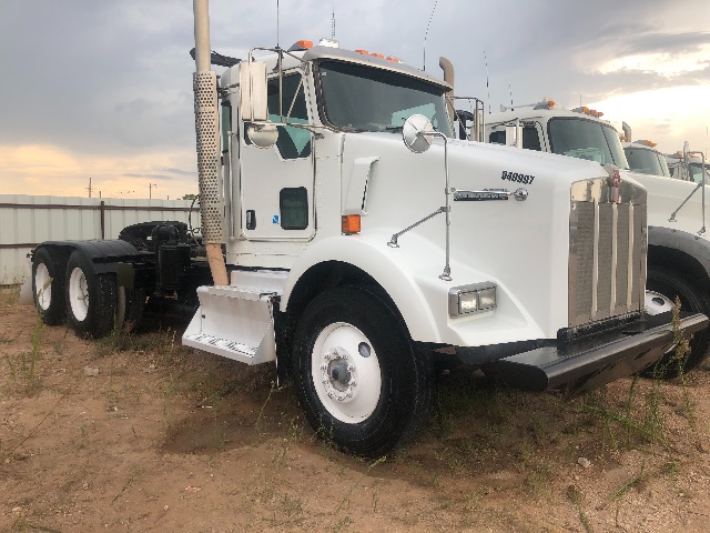 Kenworth T800 truck in white with sleeper cab, front grille, dual rear axles, and side steps.