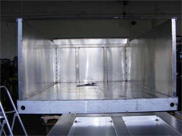 Dump body truck bed showing empty cargo space with metal interior and side panels.