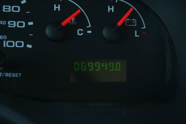 Vehicle dashboard showing odometer reading 069949.8 miles and gauge needles; green 7-segment style display.