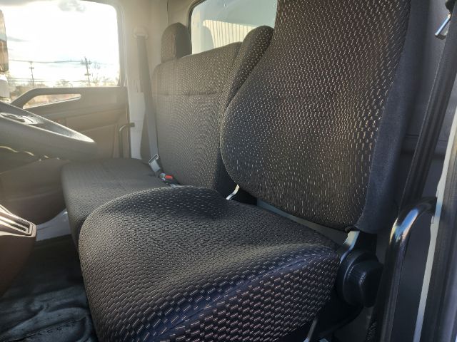 Cab interior of a 2025 Hino L6 box truck showing front bench seat and driver seat with fabric upholstery.