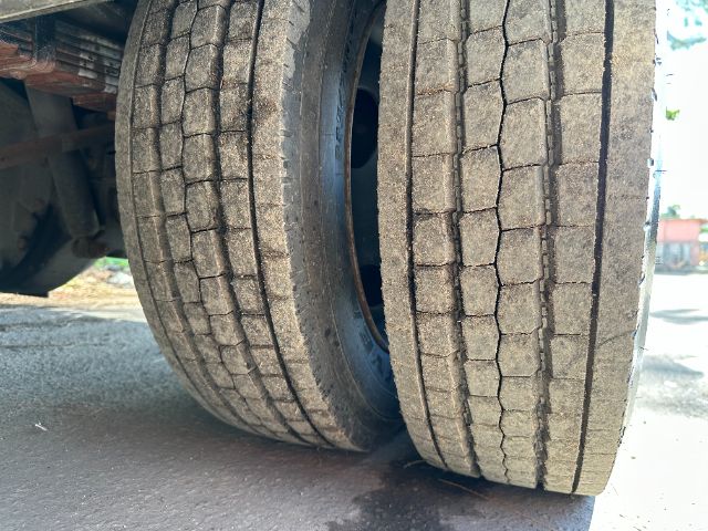 Dual rear truck tires with tread pattern visible on pavement.