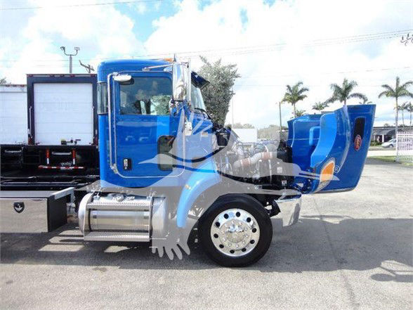Blue 2022 Peterbilt 337 truck cab and rear sleeper area with chrome exhaust and front fender, side view.