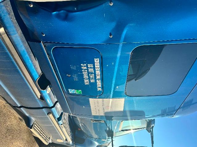 Truck hood door area of a blue 2017 International Prostar with a label and a window visible.