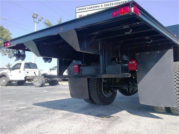 Flatbed truck body rear view showing 20 ft Advanced Fabricators flatbed with dual wheel and undercarriage components.