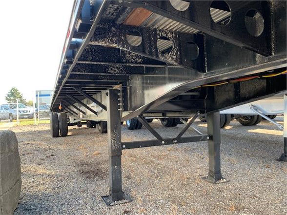 New 2024 Vanguard 48ft steel flatbed trailer undercarriage showing support legs and understructure.