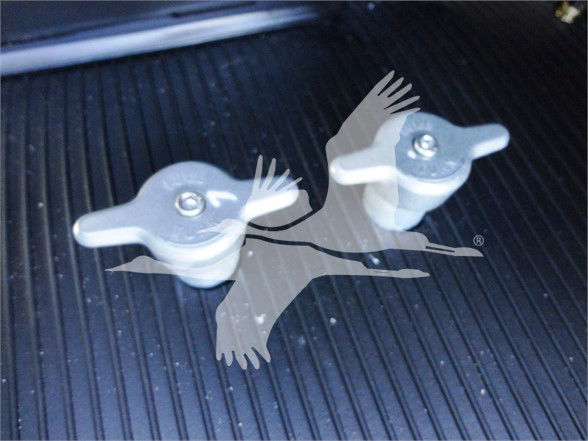 Two metal tow hooks with handles on a truck bed surface.
