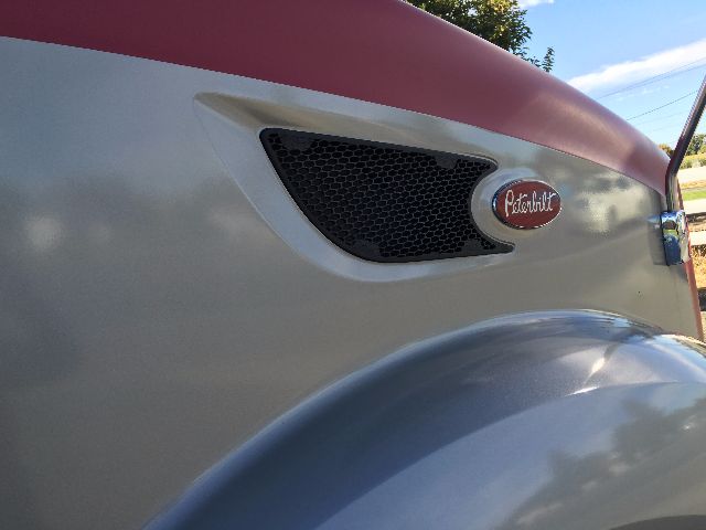 Peterbilt truck front grille and pink-gray hood badge visible