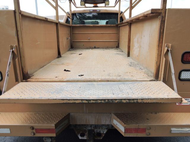 Flatbed utility bed of a 2016 Ford F350 Crew Cab with open cargo area and diamond plate floor.