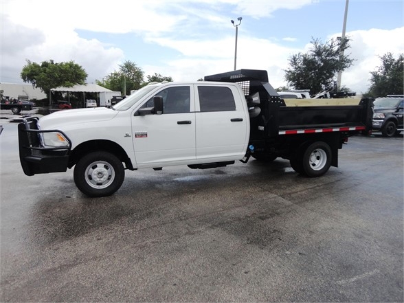 White 2012 Ram 3500 SLT crew cab long bed dump truck with black dump body.