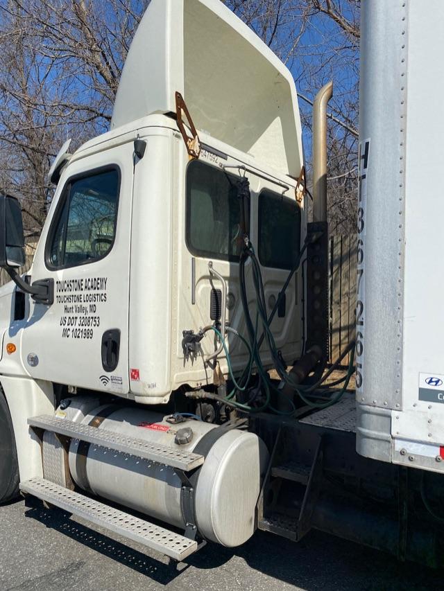 Freightliner Cascadia cab and chassis truck with sleeper removed, side view shows fuel tanks, steps, cab doors, and chassis with hoses and connectors.