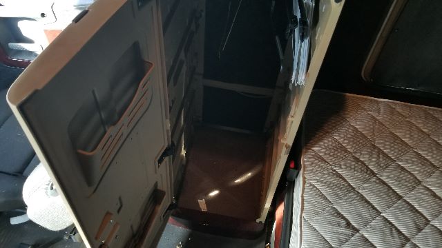 Cabin interior of a 2013 Freightliner Coronado 132 showing the entry hatch and sleeper area with quilted mattress and storage compartments.