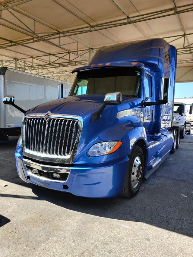 Blue 2020 International LT 625 conventional sleeper semi-truck with chrome grille, large vertical exhaust, and aerodynamic mirrors.