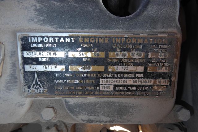 Engraved engine information plate on a Grove T60 showing engine family X0ZXLQ2 75 HP 54 kW, RPM 2000, displacement 7.7 L, certificate text about diesel fuel. Various serials and model year info blurred.