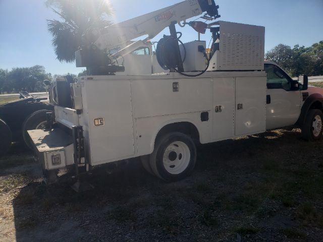 Utility bucket truck on a white Ford F550 with crane equipment mounted, side compartments, and white wheels.