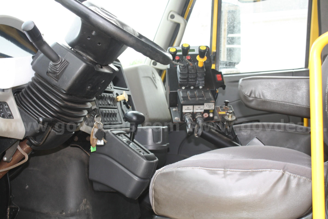 Interior of a 2012 International 7400 cab showing steering column, gear shifter, and control panel with multiple levers and switches.