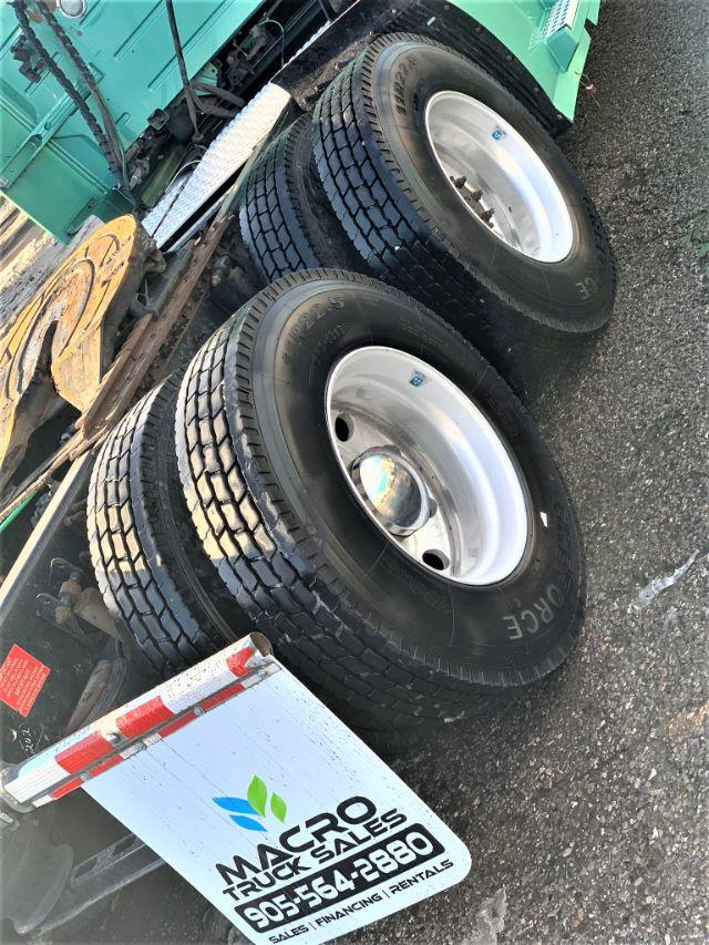 Wheelset of a 2015 Volvo VNL 670 truck showing dual rear axles with heavy-duty tires and chrome rims; close-up of tires and wheel wells.