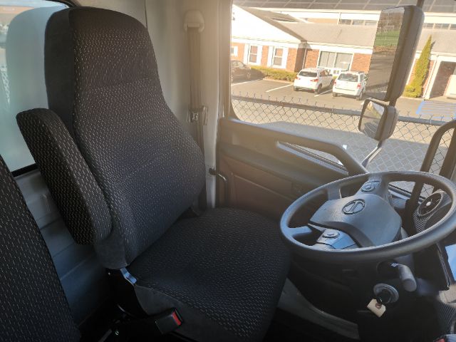 Truck cab interior showing driver seat and steering wheel in a new Hino L6 box truck.